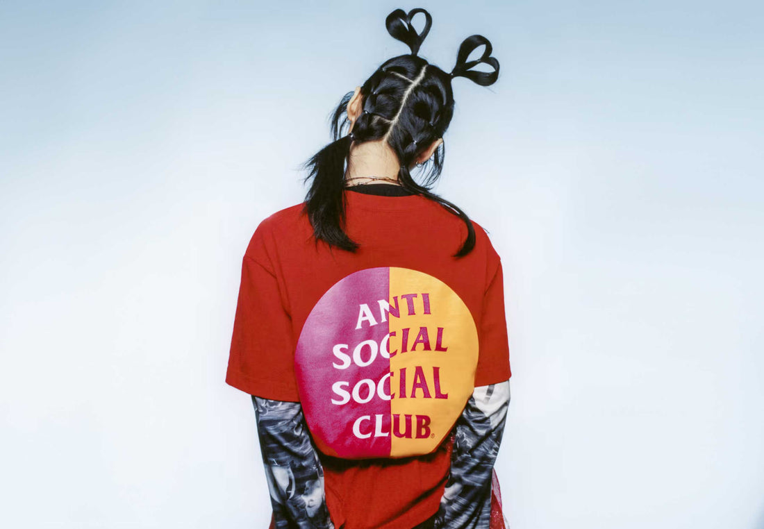 Woman with her back towards the camera wearing a Red ASSC Anti Social Social Club t-shirt showing the back graphic logo print