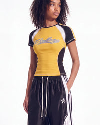 A model wearing a yellow, black, and white athletic t-shirt with 'College' written across the chest, paired with black athletic shorts with white stripes.
