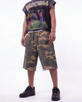 Saint Vanity Camo Long Shorts in woodland camo, front view on model showing the white drawcord and raw hem