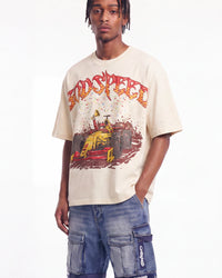 A man wearing a beige graphic t-shirt with a red and yellow 'SPEED' race car design, paired with blue cargo shorts, against a plain white background.