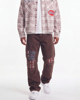 Bravest Studios Liberty Flare Denim brown, waist-down front view on model showing the flared leg and flag rips