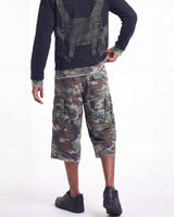 A model from the back wearing a black long-sleeve shirt with a green tactical harness graphic, green camouflage cargo shorts, and black shoes, against a plain white background.