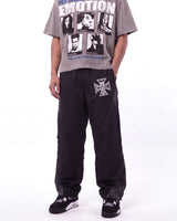Mixed Emotions Classic Nylon Pant black, waist-down front view on model showing the rhinestone Iron Cross logo
