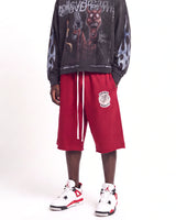 Saint Vanity Crimson Uniform Shorts red, waist-down front view on model showing the crest logo and drawcord