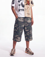 Bravest Studios Half Puzzle Tee tan, worn on model with camo cargo shorts, lower front view