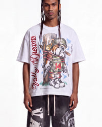 A model wearing a white graphic t-shirt featuring a bulldog in a football helmet with 'Valley Dreams' written vertically in red script, paired with dark gray graphic pants.