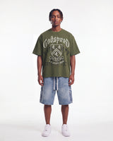 Godspeed Collegiate Tee Olive Wash, worn by a model with light wash denim shorts, full front view