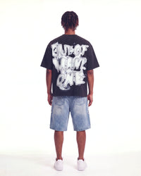 Godspeed No Risk No Reward Tee Black Wash, worn by a model, full-length back view showing the bubble lettering