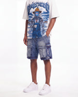 A model wearing a white graphic t-shirt with a blue robot print, blue denim cargo shorts with 'Cruze' branding on the pocket, and white sneakers, shown from the waist down against a white studio background.