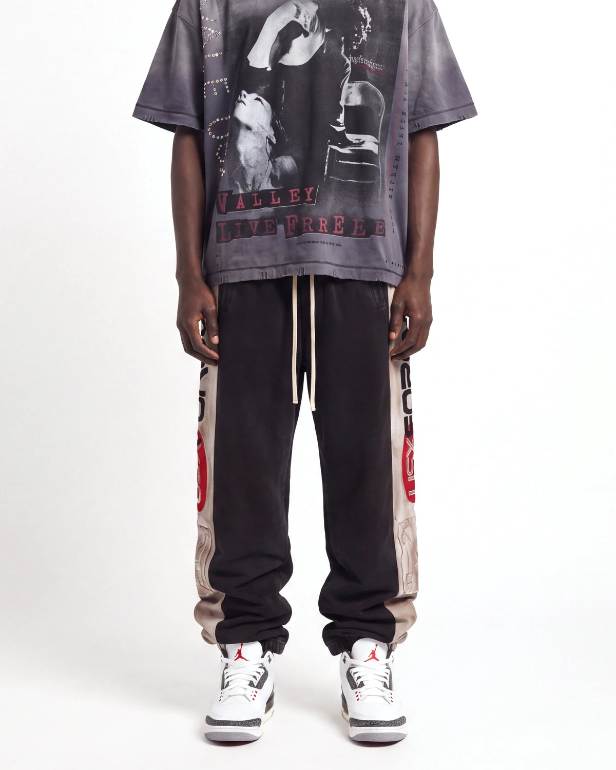 Vale Forever Vale Star Sweatpants black, front view on model showing the tan side panels and drawcord waist