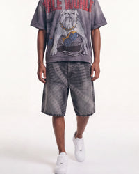 A model wearing a gray acid-wash graphic t-shirt with a bulldog print and red text, matching acid-wash shorts, and white sneakers, shown from the chest down against a white studio background.
