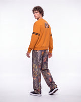 HMDD Chim Tree H-Star Nylon Pants camo, side and rear view on model worn with an orange crewneck