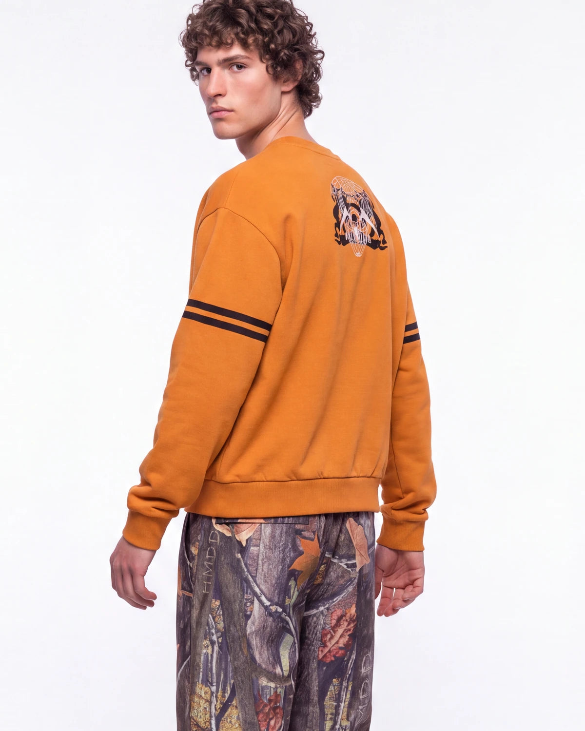 Sp5der Aranea Crewneck burnt orange, upper body rear view on model showing the sp5der crest back print