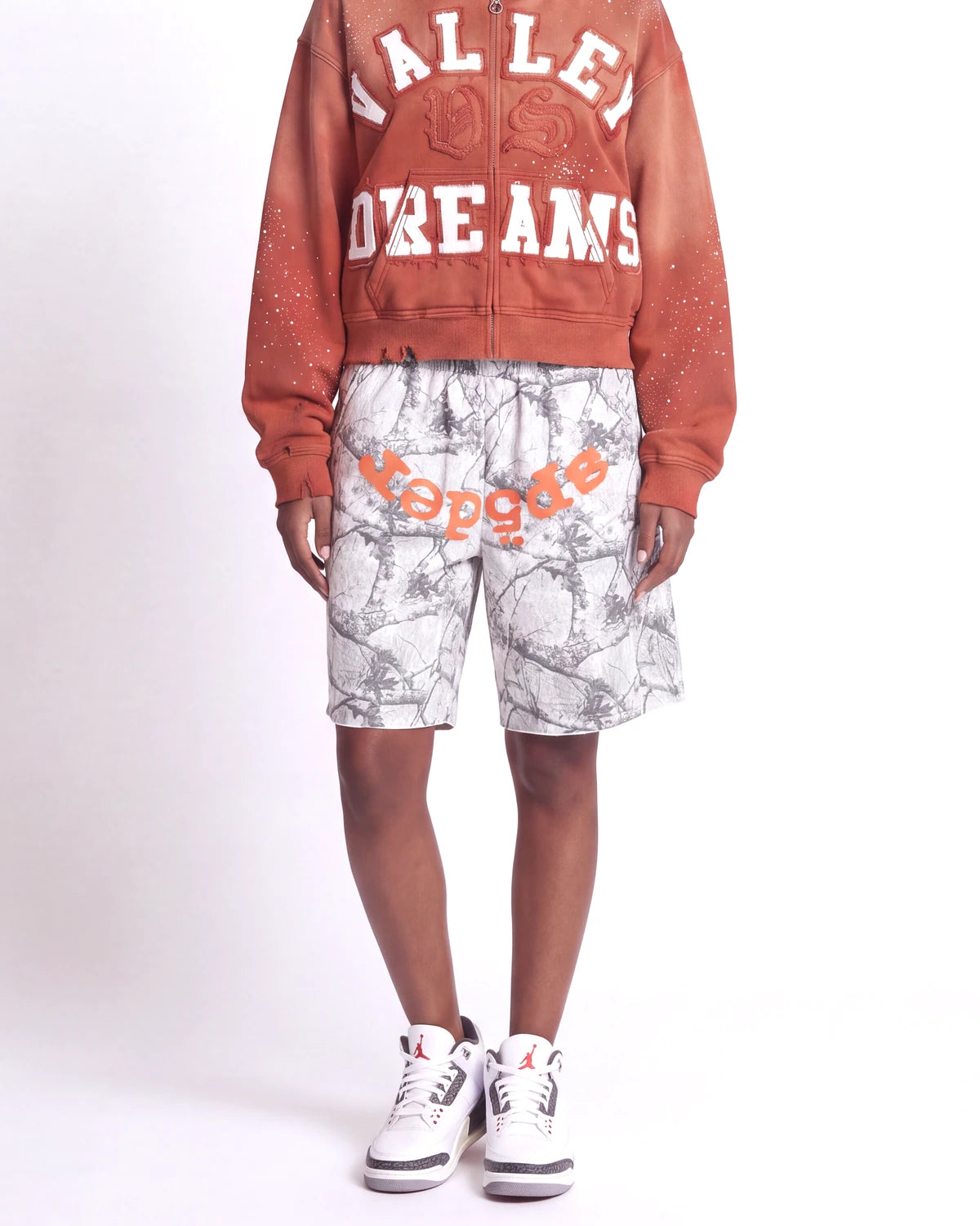 Sp5der Realtree OG Web V2 Sweat Shorts white camo, waist-down front view on model showing the orange sp5der logo