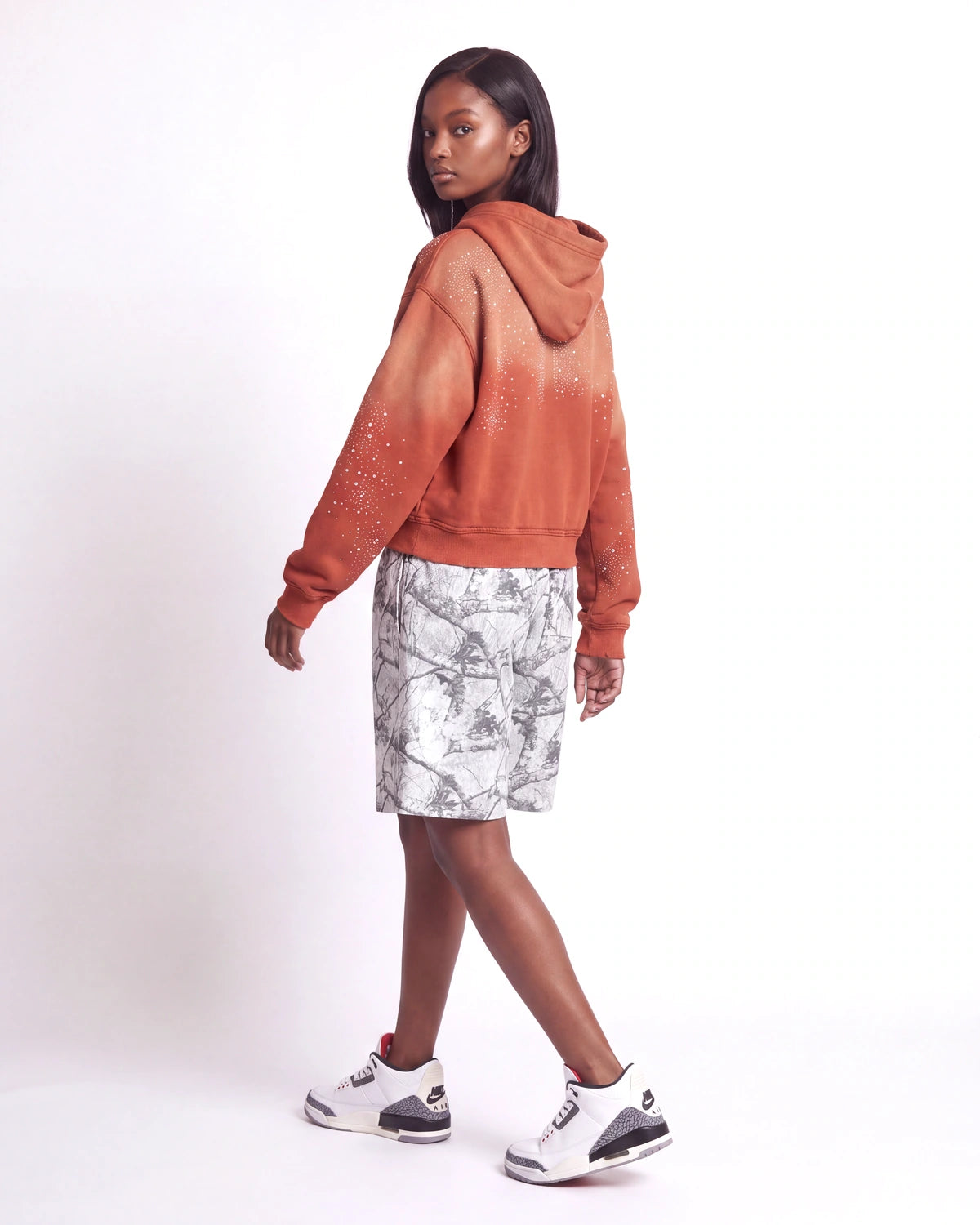Sp5der Realtree OG Web V2 Sweat Shorts white camo, side and rear view on model worn with an orange zip-up hoodie