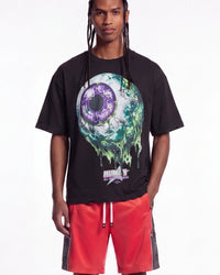 All Human Hereditary Tee black, upper body front view on model showing the dripping green and purple eyeball graphic