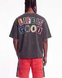 All Human Copy & Paste Tee black, upper body rear view on model showing the multicolored LIFE IS GOOD letters