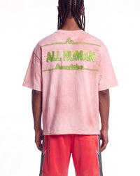 All Human Champagne Room Tee pink, upper body rear view on model showing the green ALL HUMAN lettering