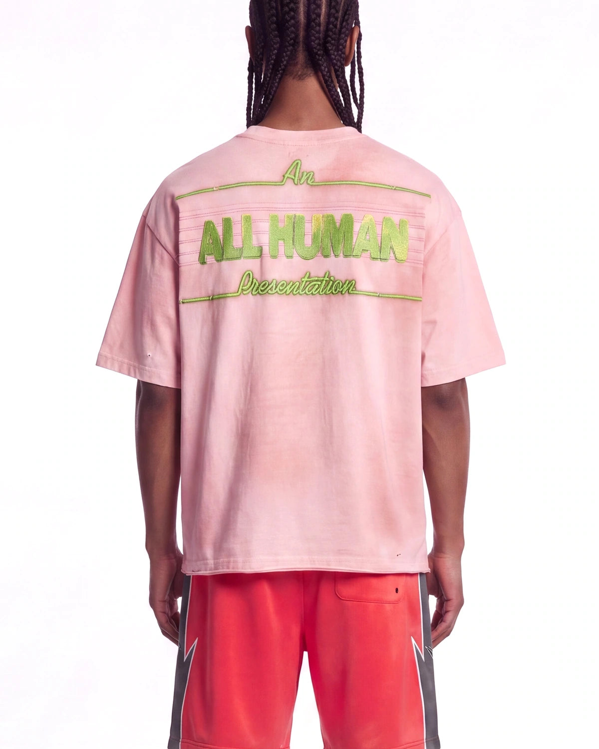 All Human Champagne Room Tee pink, upper body rear view on model showing the green ALL HUMAN lettering