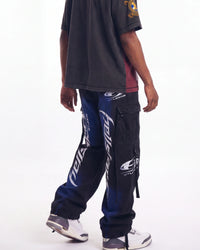Hellstar Printed Cargo Pants black, waist-down rear view on model showing the blue spray fade and leg lettering