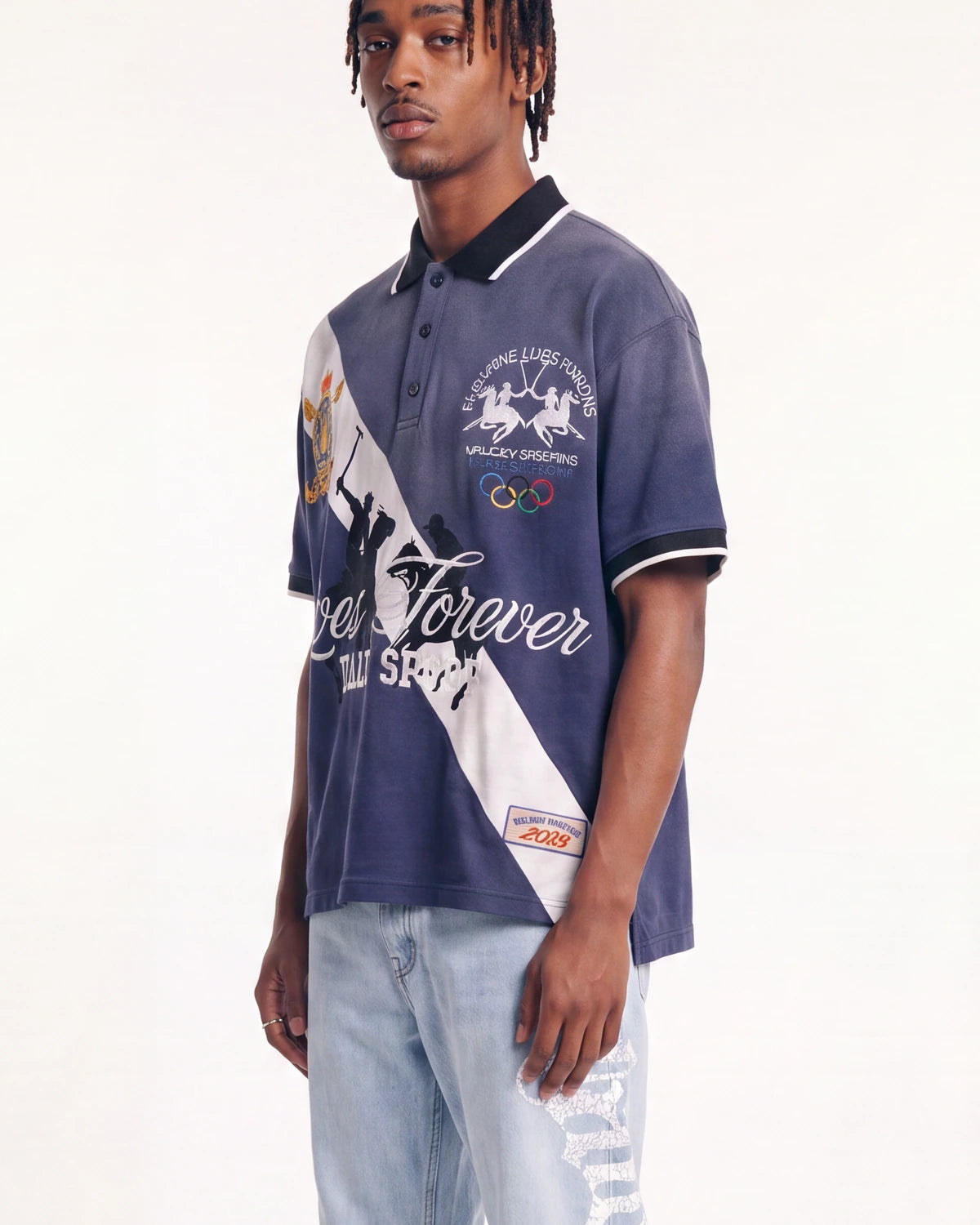 A man wearing a navy blue and white graphic polo shirt with 'Forever Your Style' text and horse racing graphics, paired with light-wash ripped jeans, against a plain white studio background.