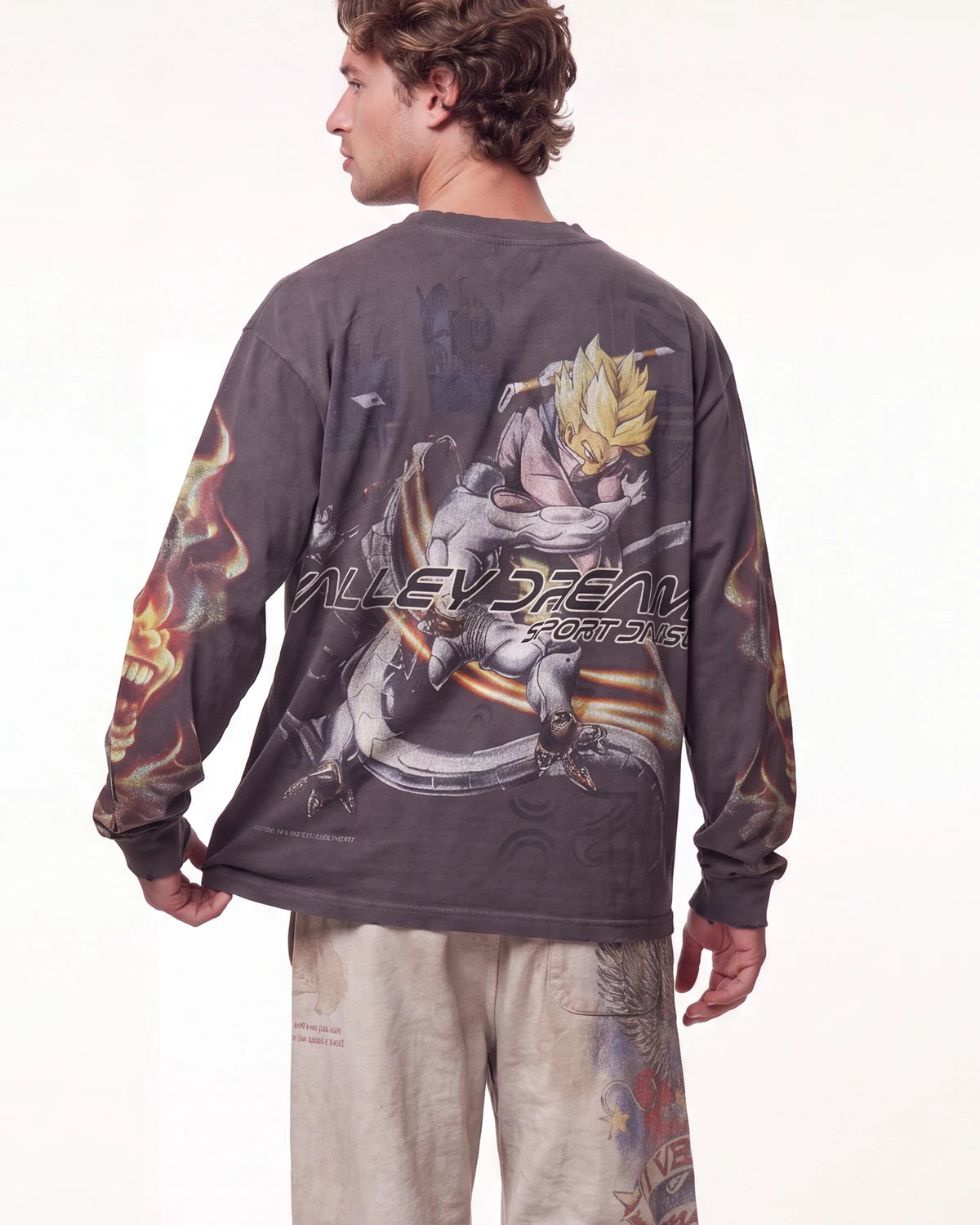 A man shown from the back wearing a dark gray long-sleeve t-shirt with a large graphic of Super Saiyan Gohan and the text 'ALLEY BREATHE FUTURE' across the back, paired with light beige pants.