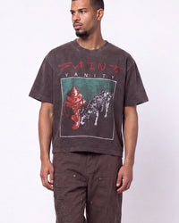 A man wearing a Saint Vanity brand brown graphic t-shirt and matching brown cargo pants, standing against a plain white studio background.