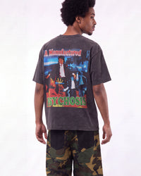 A man shown from the back wearing a faded dark gray graphic t-shirt with a large 'Psycho' print and camouflage pants, against a plain white background.