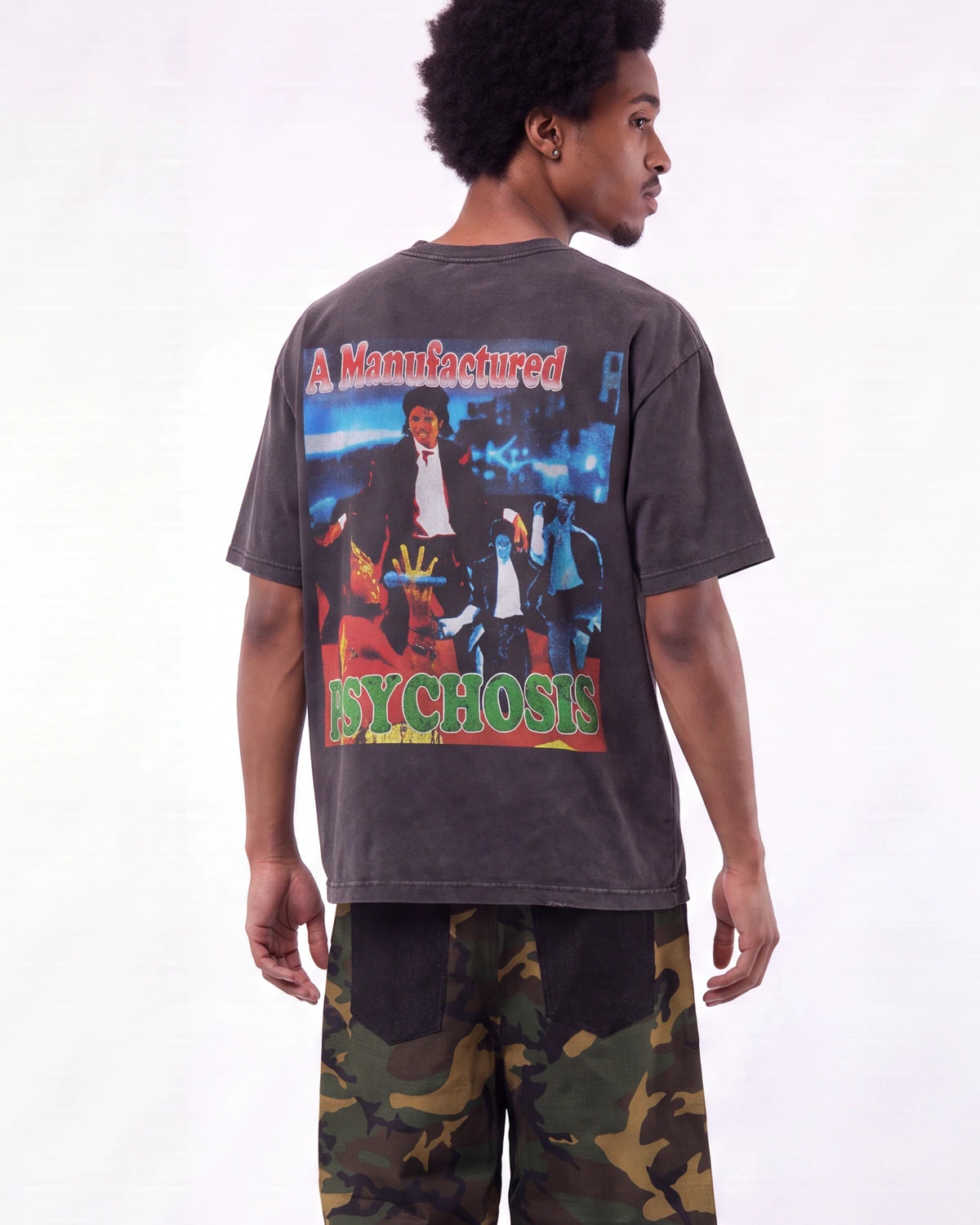 A man shown from the back wearing a faded dark gray graphic t-shirt with a large 'Psycho' print and camouflage pants, against a plain white background.