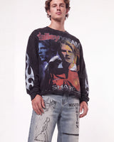 A male model wearing a black long-sleeve graphic sweatshirt featuring football player David Taylor and Manchester United imagery, paired with light-wash distressed jeans against a plain white studio background.