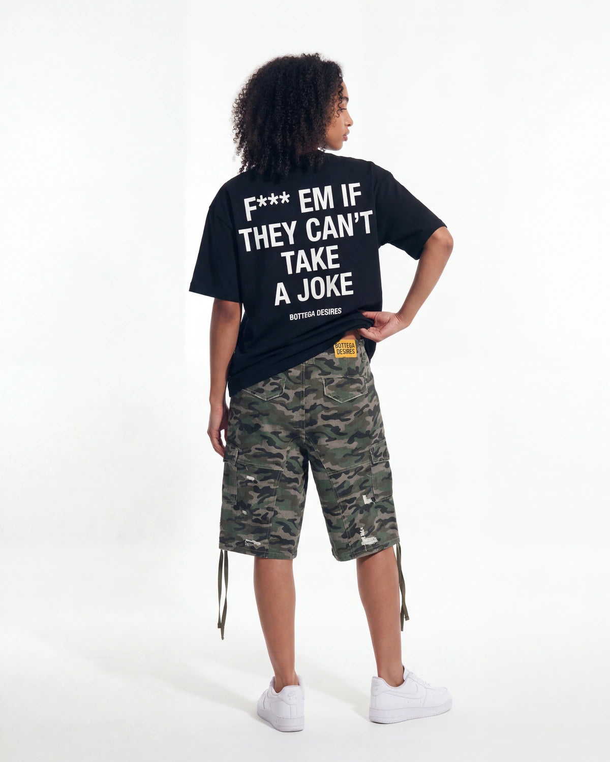 Restock AR Outfit #36, black oversized tee with white block-text back print styled with woodland camo cargo shorts, back view of the full look