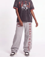 Boredom Kills Collegiate Sweats grey and red, waist-down front view on model showing the red collegiate lettering