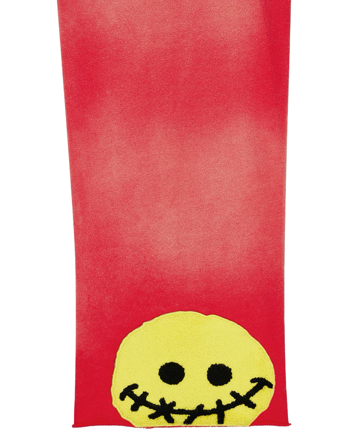 All Human 2+2=5 V2 Sweatsuit red wash, close-up of the stitched smiley patch on the pant leg