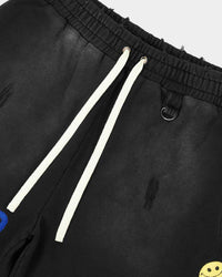 All Human Honey Moon Shorts V2 black, close-up of the drawcord waist and yellow smiley patch
