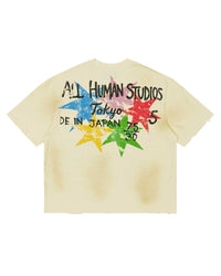 All Human Shinjuku Tee cream, back view showing the ALL HUMAN STUDIOS Tokyo lockup over a burst of multicolor stars