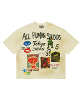 All Human Shinjuku Tee cream, faded cotton tee with hand-drawn ALL HUMAN STUDIOS Tokyo lettering, a green kaiju and vintage poster clippings, front view