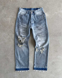 Bravest Studios Dirty Star Denim blue, flat-lay front view on concrete showing the baggy leg and knee blowouts