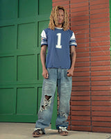 Bravest Studios Dirty Star Denim blue, model shot showing the baggy full-length fit stacking at the ankle