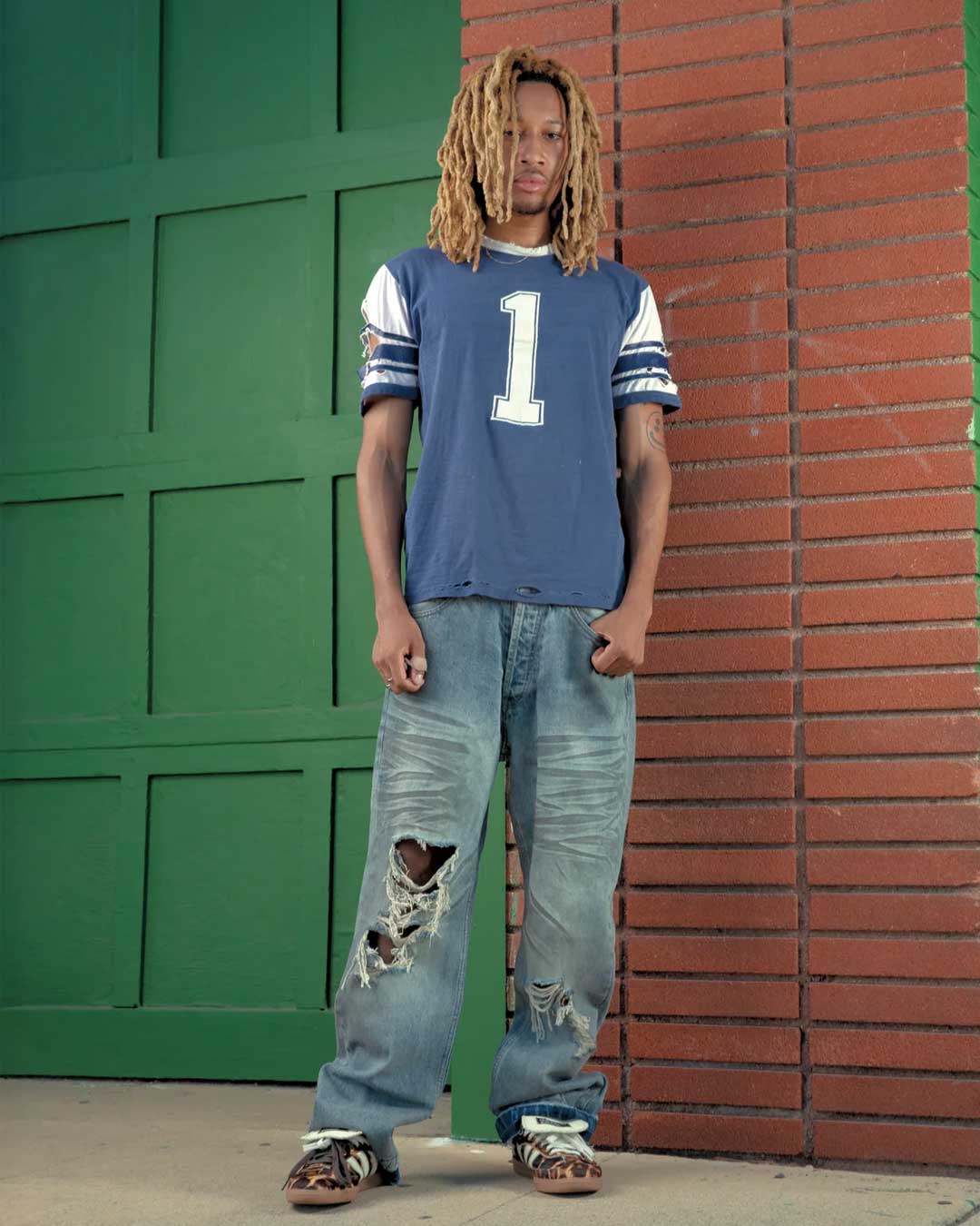 Bravest Studios Dirty Star Denim blue, model shot showing the baggy full-length fit stacking at the ankle