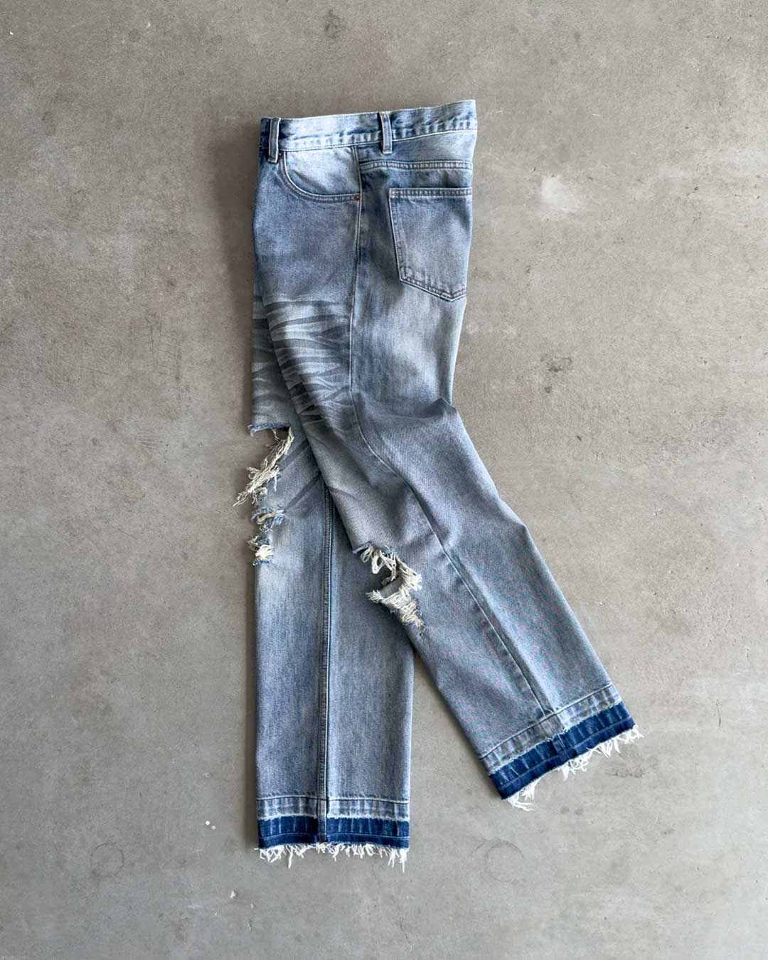 Bravest Studios Dirty Star Denim blue, flat-lay side view showing the shredded knees and released cuff