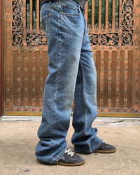 Bravest Studios Flare Denim Pants blue, close model shot of the flared leg stacking over the shoe