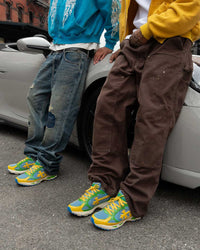 Bravest Studios Kross Kountry Runner Brazil, two models wearing the pair beside a silver sports car on the street