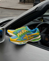 Bravest Studios Kross Kountry Runner Brazil, single shoe resting on the door of a silver Porsche showing the side profile and yellow laces
