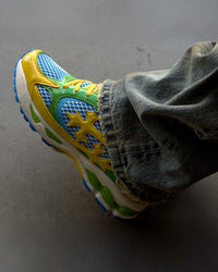 Bravest Studios Kross Kountry Runner Brazil, close-up worn on foot with washed denim showing the yellow cross applique and blue outsole