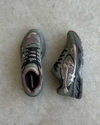 Bravest Studios Kross Kountry Runner Camo, top-down and side view on concrete showing the black laces and camo mesh panels