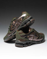 Bravest Studios Kross Kountry Runner Camo, olive and brown camo mesh runner with a bronze cross applique, pair stacked on a dark gradient backdrop