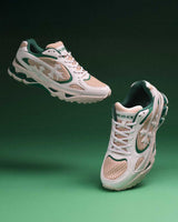 Bravest Studios Kross Kountry Runner Spring Green, pair floating on a green backdrop showing the kelly green overlays and tan mesh panels