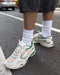 Bravest Studios Kross Kountry Runner Spring Green, worn on foot with white crew socks on asphalt, angled view