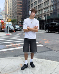 Bravest Studios Kross Kountry Runner Triple Black, worn on a city street corner with a white tee and black denim shorts, full outfit view