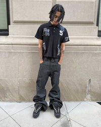 Bravest Studios Patch Polo black, full-length model shot styled with black flared denim